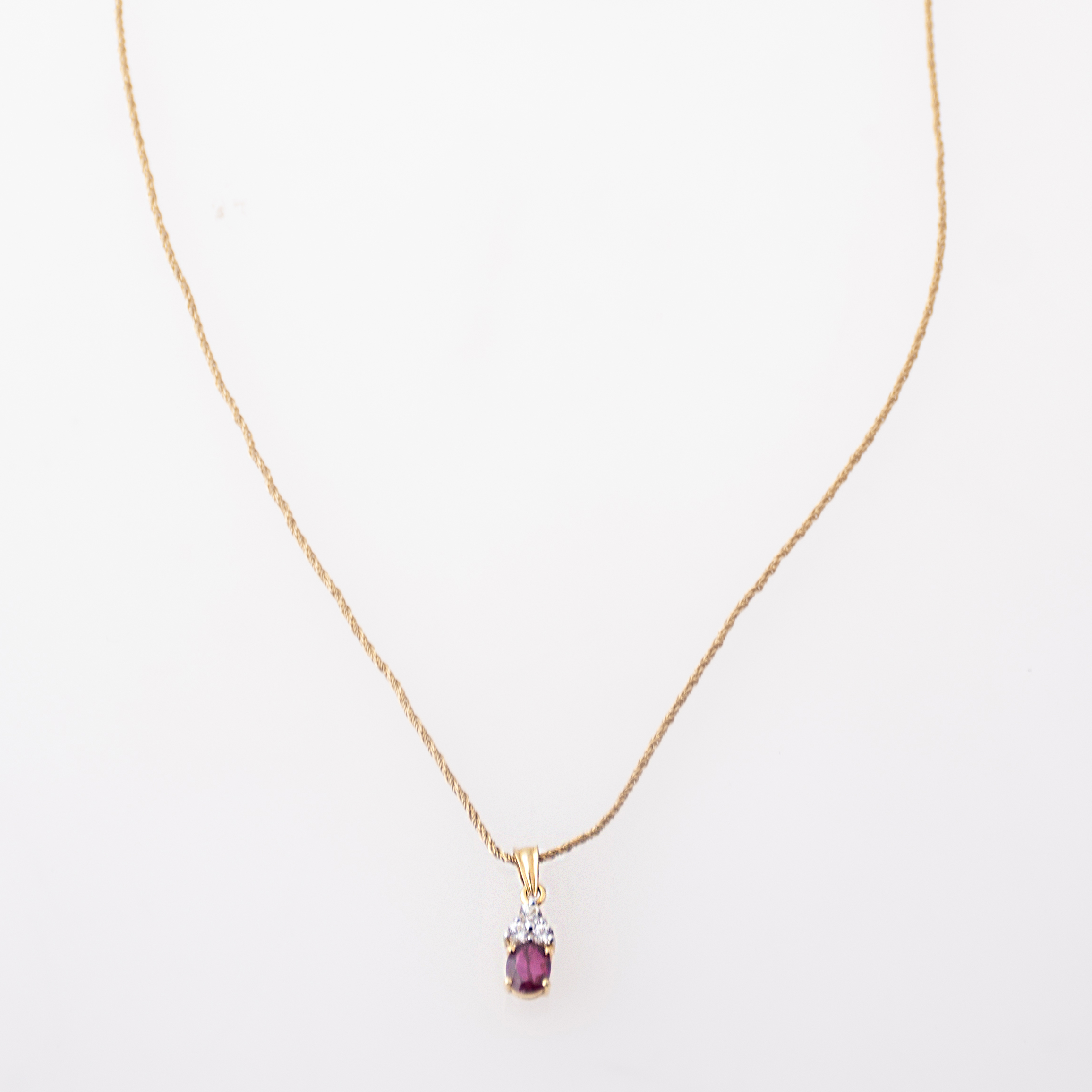 Necklace with ruby and white sapphire pendant.