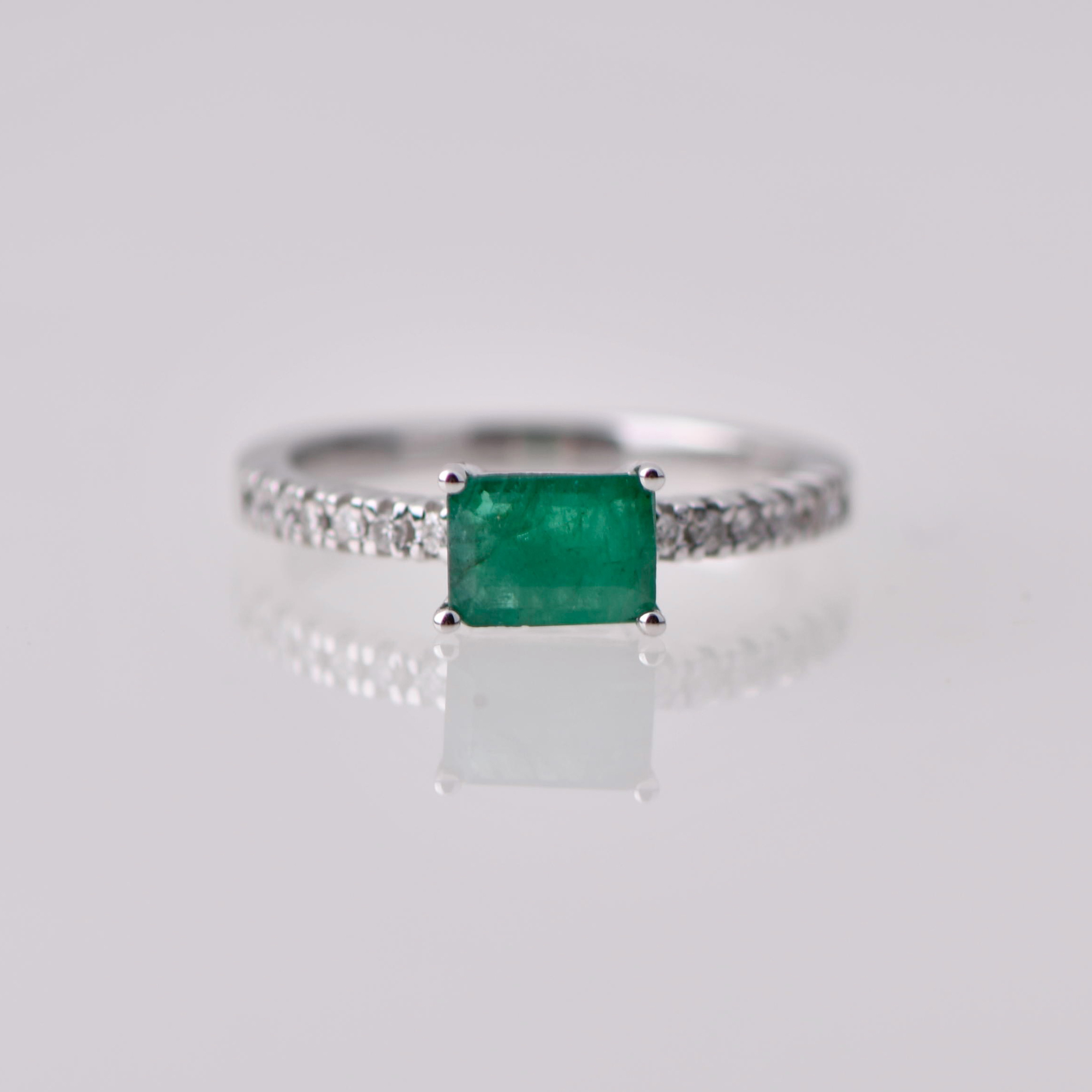 Half weddig ring with a central emerald
