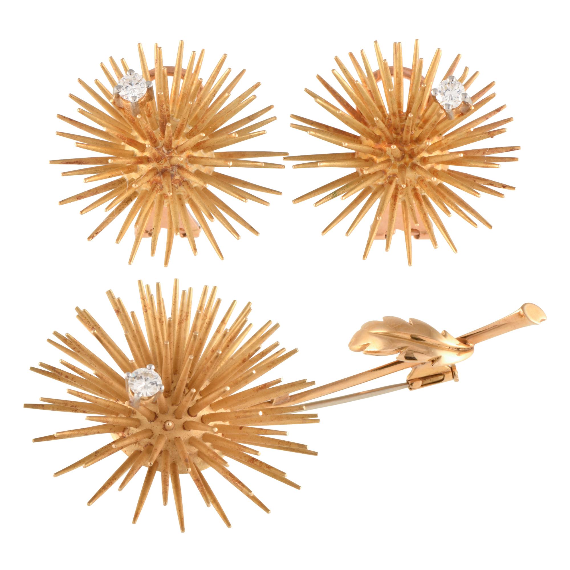 Floral brooch and earrings set with diamonds.