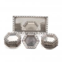 12-Hallmarked. Rectangular tray with openworked borders and fifteen hexagonal matching plates. 15x8 cms. the tray; 6,5 cms. diam. the plates. 681 gr.