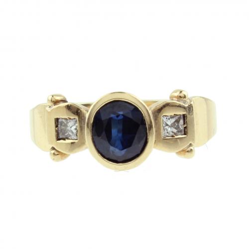 Oro con zafiro central de talla oval de aprox. 0,50 ct. y dos diamantes de talla princesa de aprox. 0,20 ct.Aro de 18 mm.4,8 gr.