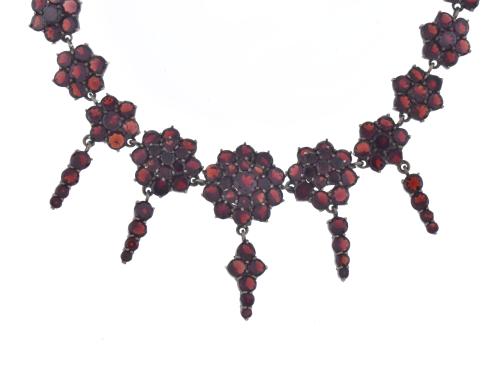 Collar y broche con formas florales con granates.