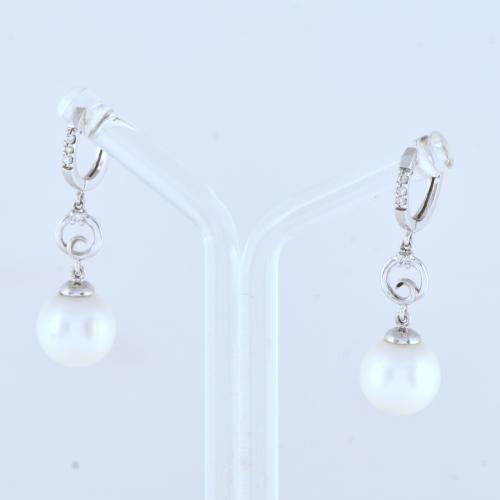 Pendientes aretes con perlas colgantes.