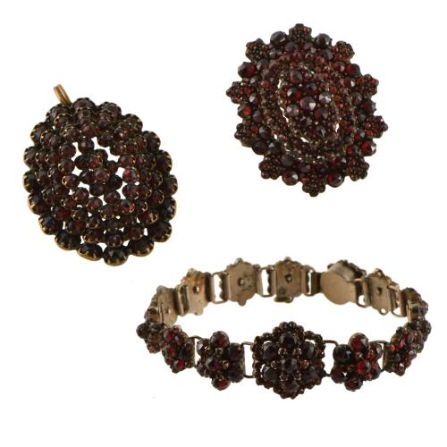 Conjunto de pulsera colgante y broche en formas florales  con granates.