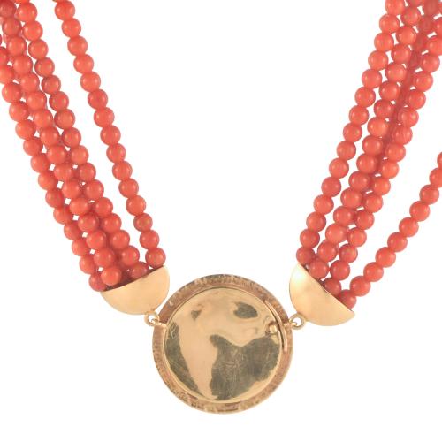 Necklace with coral beads with coin-shaped pendant.