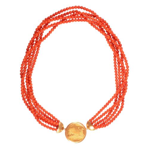 Necklace with coral beads with coin-shaped pendant.