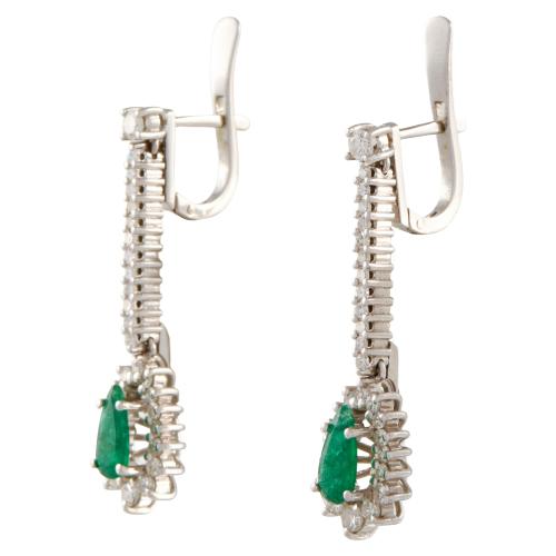 Pendientes largos con esmeraldas orladas de diamantes.