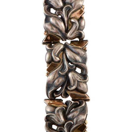 Pulsera ancha articulada modernista con motivos florales.