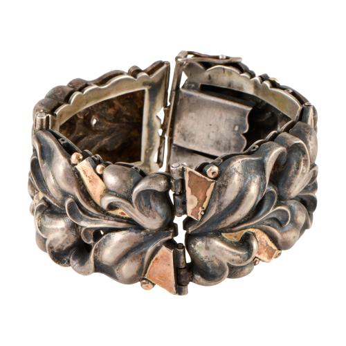 Pulsera ancha articulada modernista con motivos florales.