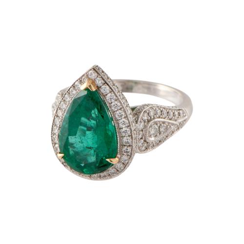Anillo con esmeralda orlada de diamantes.