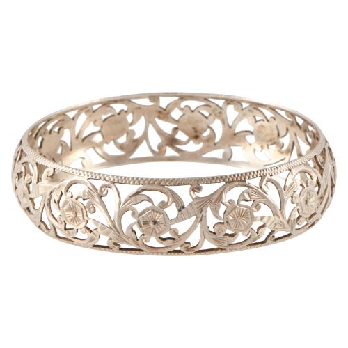 Pulsera ancha rígida calada con motivos florales.